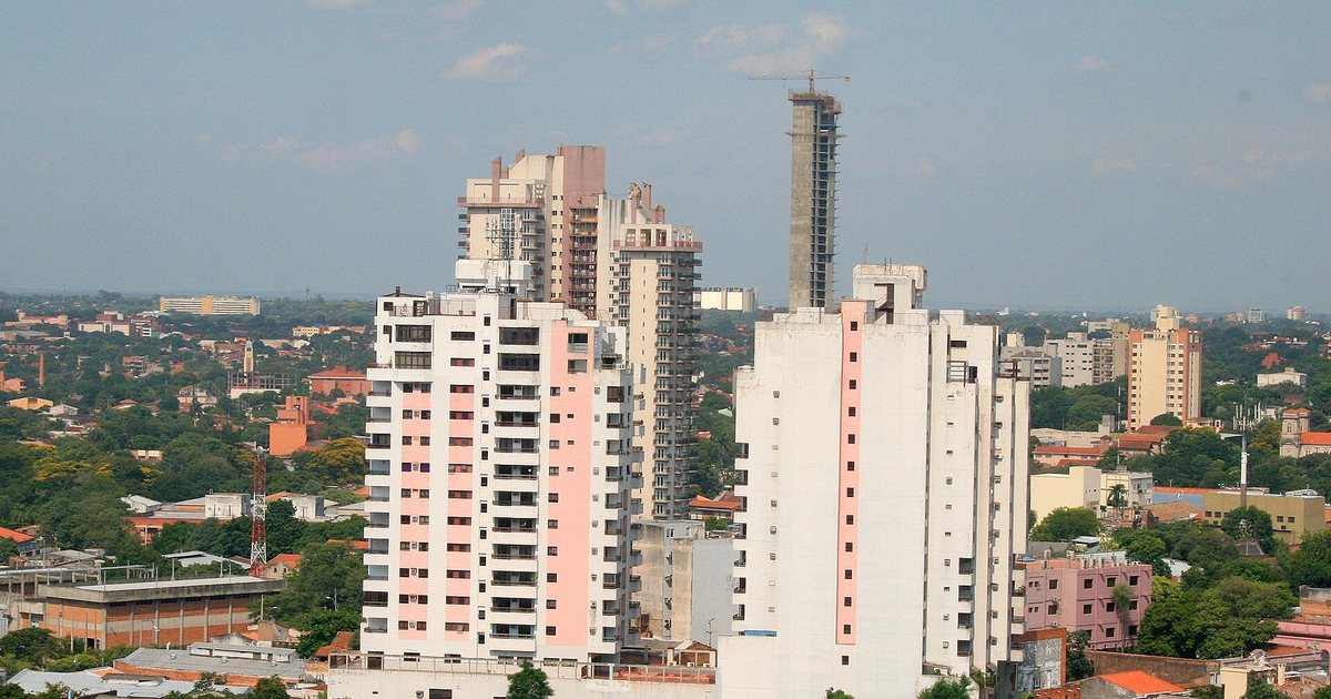 Edificios de departamentos y casas en una zona residencial de Asunción, con una torre en construcción