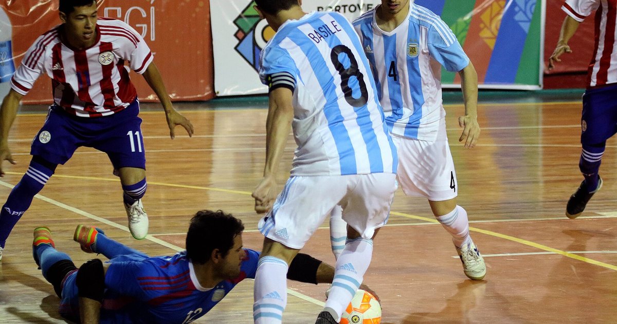 Jugadores de las selecciones de Argentina y Paraguay disputan la pelota en un partido de futsal