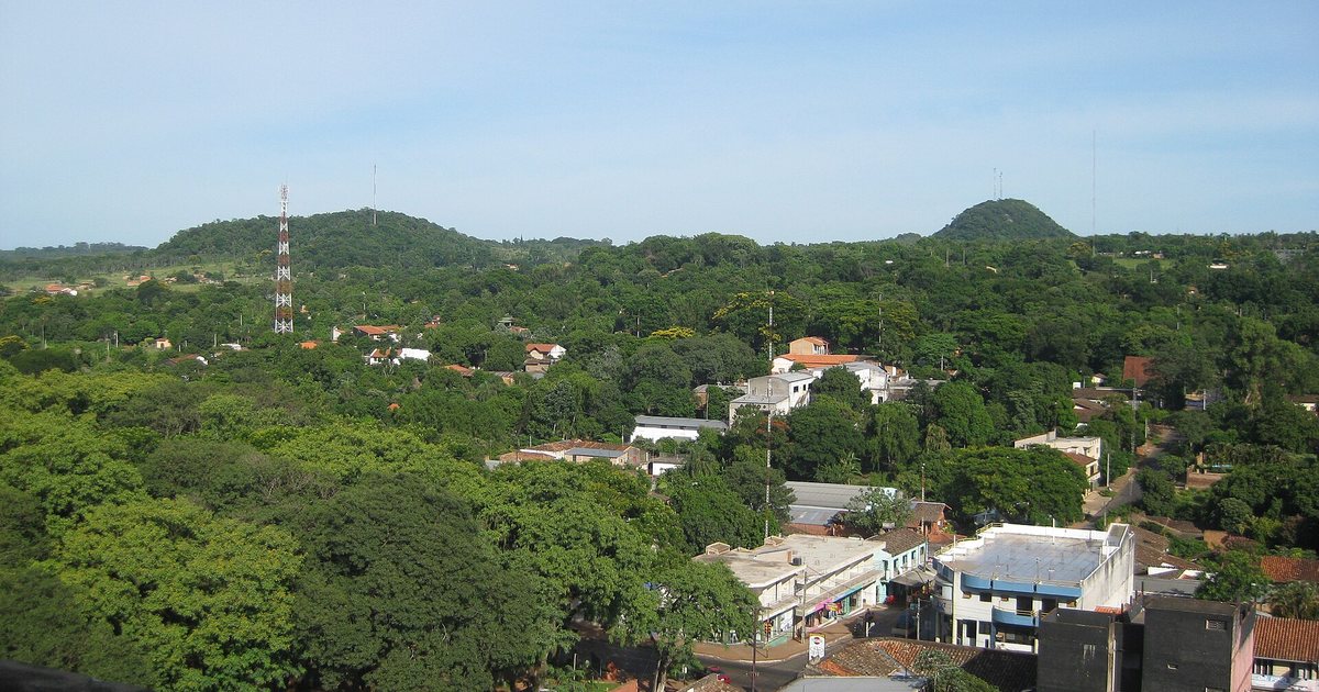 Casas y arboledas de Caacupé vistas desde lo alto, con los cerros de Cordillera al fondo