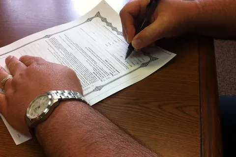 Foto: danielmoyle / Flickr · CC BY 2.0 Mano firmando un documento