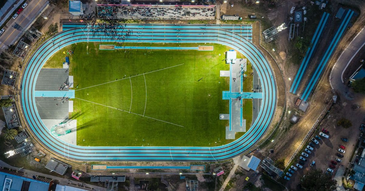 Vista aérea al anochecer de la pista de atletismo del CARD de Santa Fe, con las fosas de salto en largo a los costados