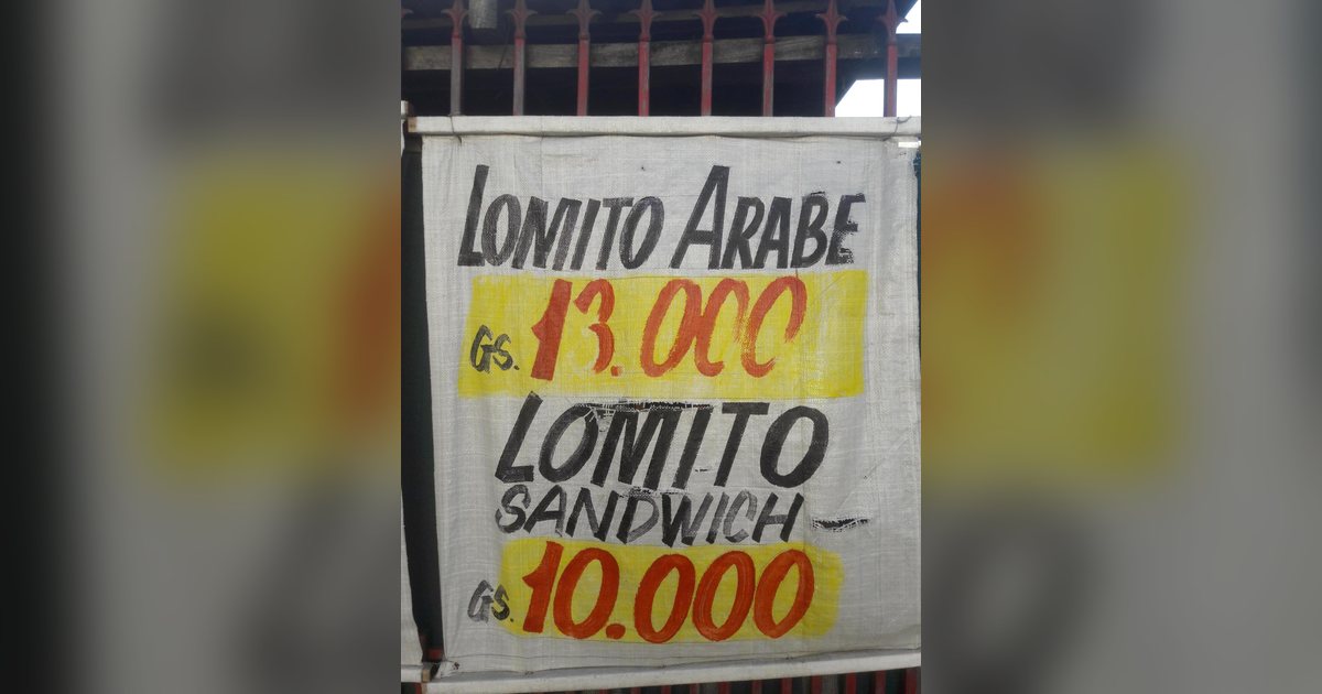 Cartel escrito a mano con precios de lomitos en guaraníes, en Paraguay