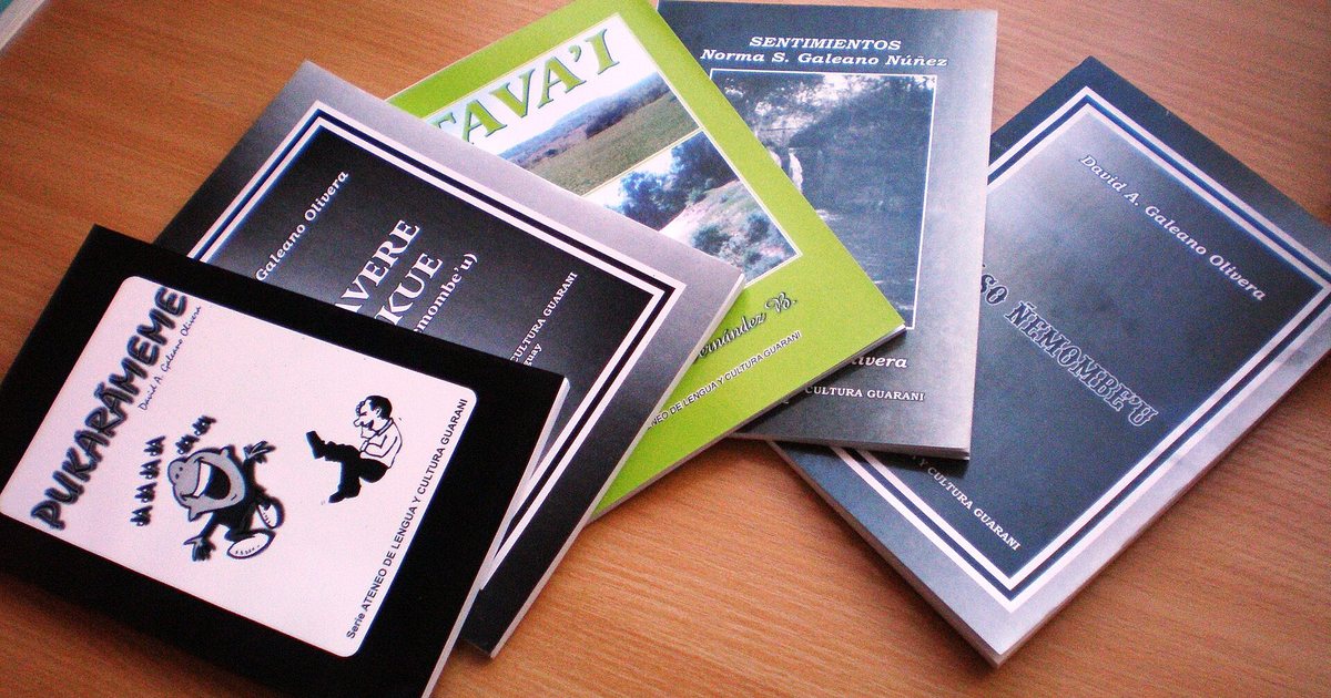 Libros paraguayos escritos en guaraní, sobre una mesa de madera