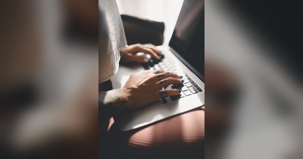Manos que escriben en el teclado de una computadora portátil