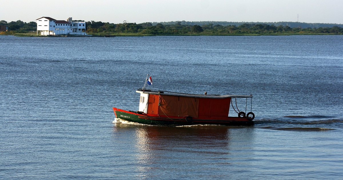 Una lancha con la bandera paraguaya navega por el río Paraguay en la bahía de Asunción