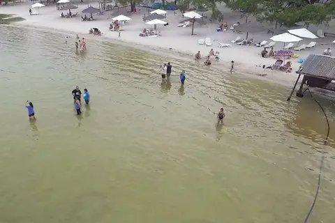 Bañistas en la orilla de arena blanca de la Laguna Blanca, en Santa Rosa del Aguaray