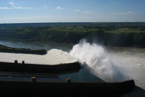 Agua que sale con fuerza de un vertedero sobre el río