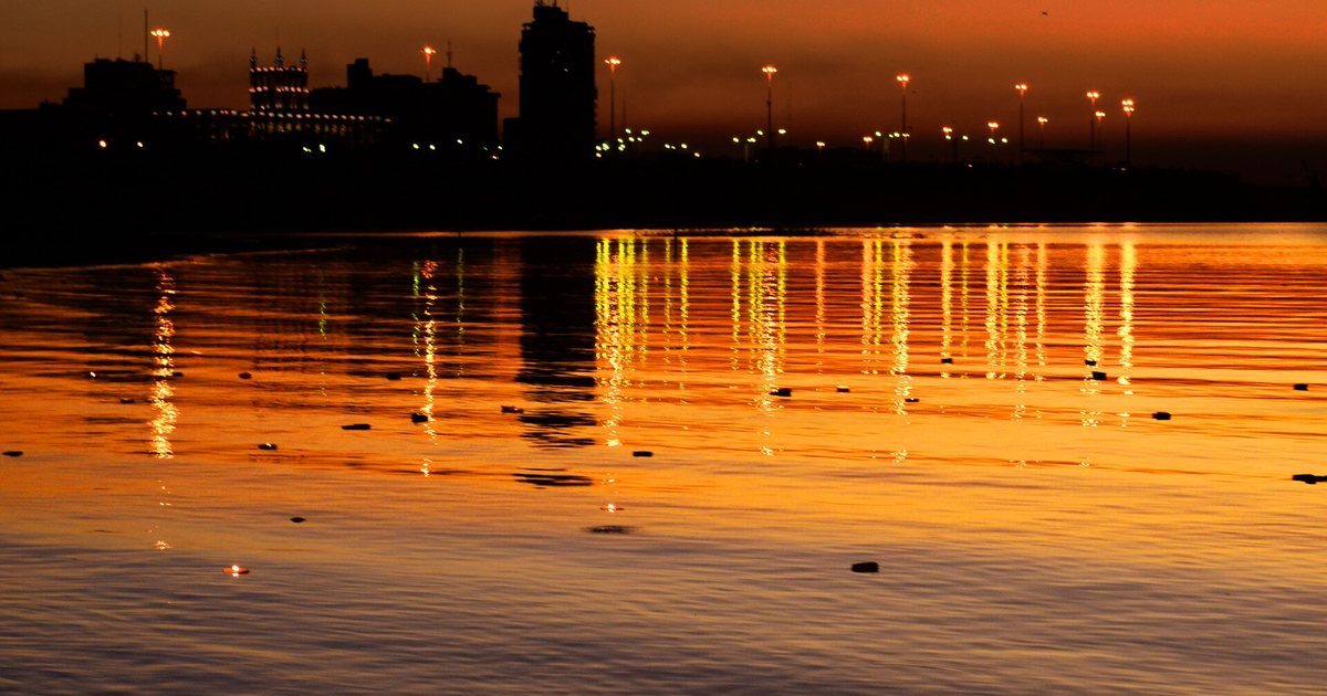 La bahía de Asunción al atardecer, con las luces de la costanera reflejadas en el río Paraguay