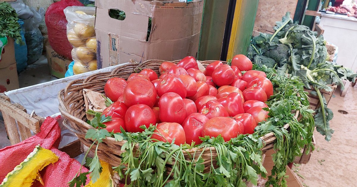 Tomates frescos en una canasta de un puesto de verduras