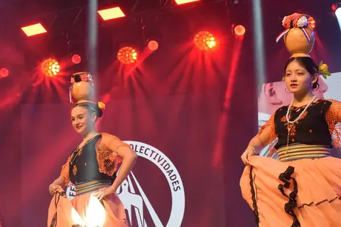 Bailarinas de la danza de la botella en un escenario con luces rojas