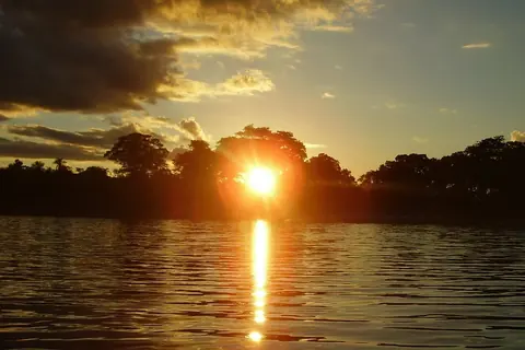Foto: Hugo Diaz Lavigne / Wikimedia Commons · dominio público Atardecer sobre el agua de la Laguna Blanca, con el bosque de la orilla, en Santa Rosa del Aguaray