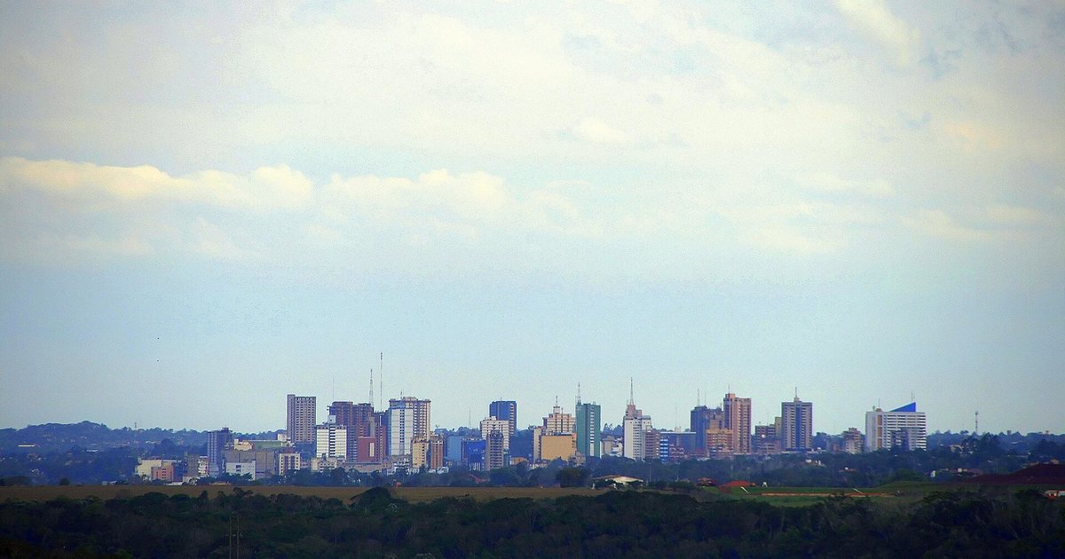 Edificios del centro de Ciudad del Este vistos a lo lejos bajo un cielo nublado, en Alto Paraná