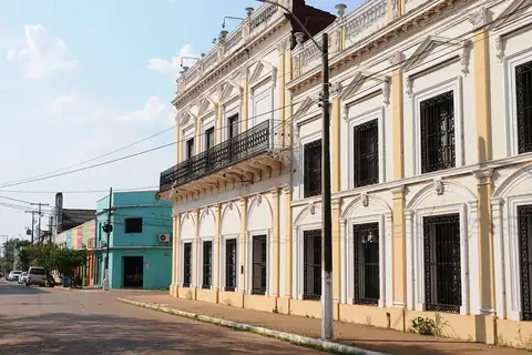 Foto: Josep M. Gracia / Wikimedia Commons · CC BY-SA 4.0 Una casona de dos plantas con balcón de hierro y ventanas enrejadas en una calle adoquinada cerca del puerto de Concepción