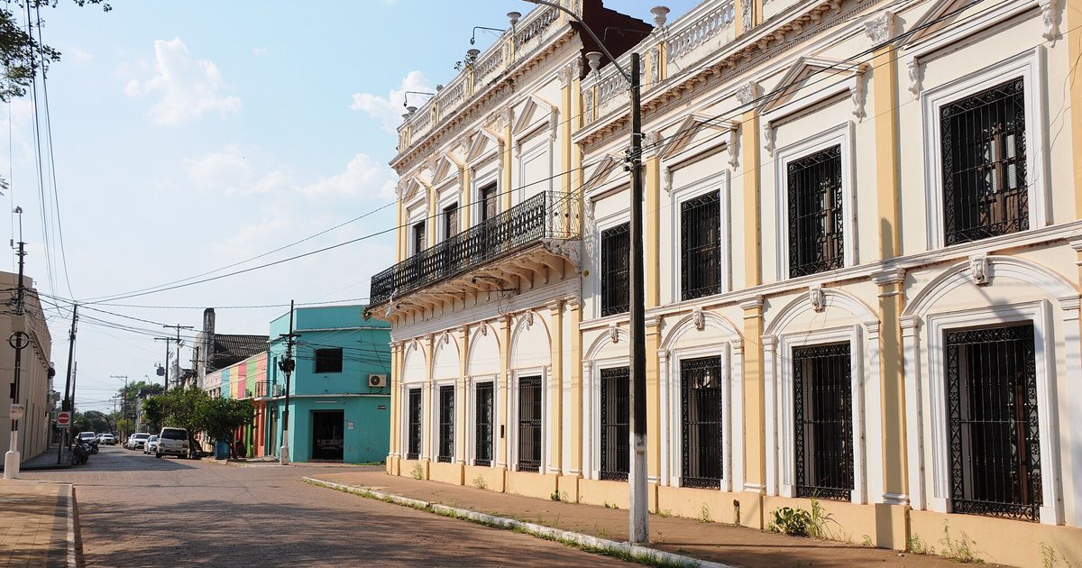 Una casona de dos plantas con balcón de hierro y ventanas enrejadas en una calle adoquinada cerca del puerto de Concepción