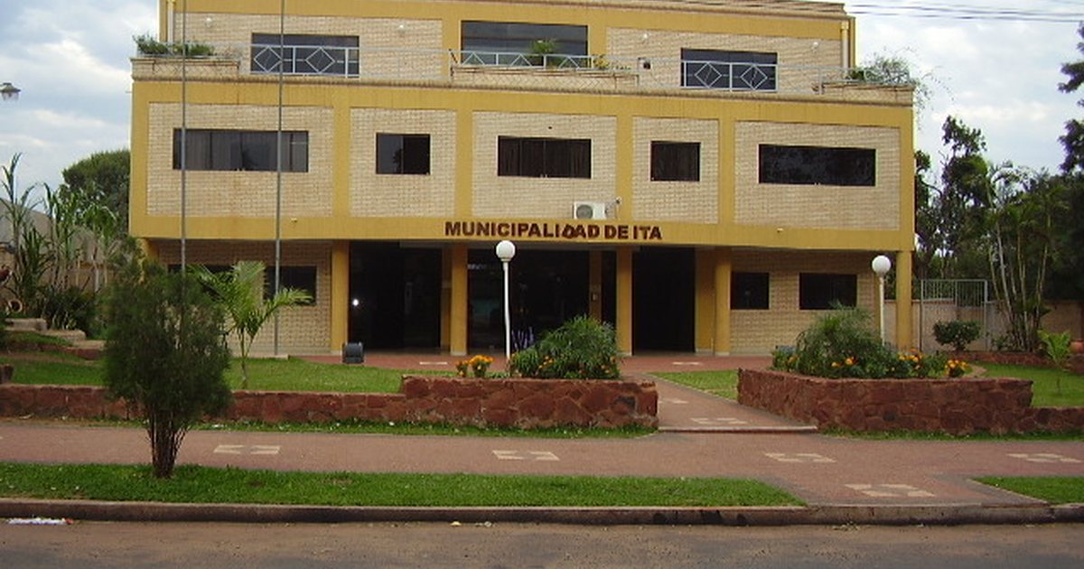 El edificio de tres plantas de la Municipalidad de Itá, de ladrillo con franjas amarillas, con canteros y faroles frente a la entrada