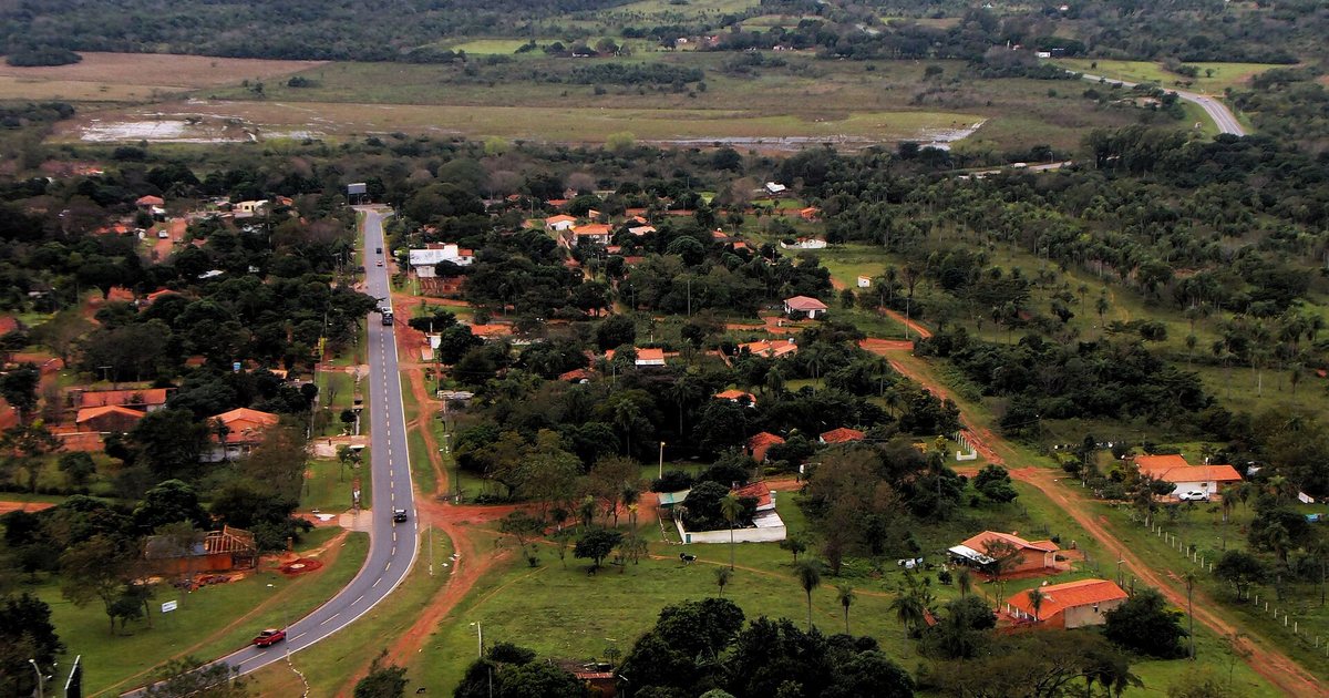 Vista de Yaguarón desde lo alto del cerro, con la ruta que cruza la ciudad, casas de techos rojos entre árboles y campos al fondo
