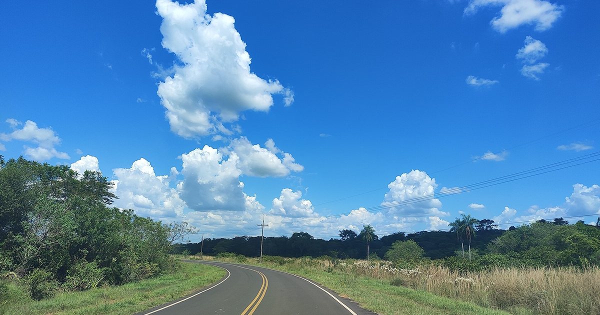 Una ruta asfaltada de dos carriles entre campos y monte en el interior del Paraguay