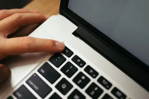 Mano sobre el teclado de una computadora portátil, como las que se usan para consultar un expediente en línea