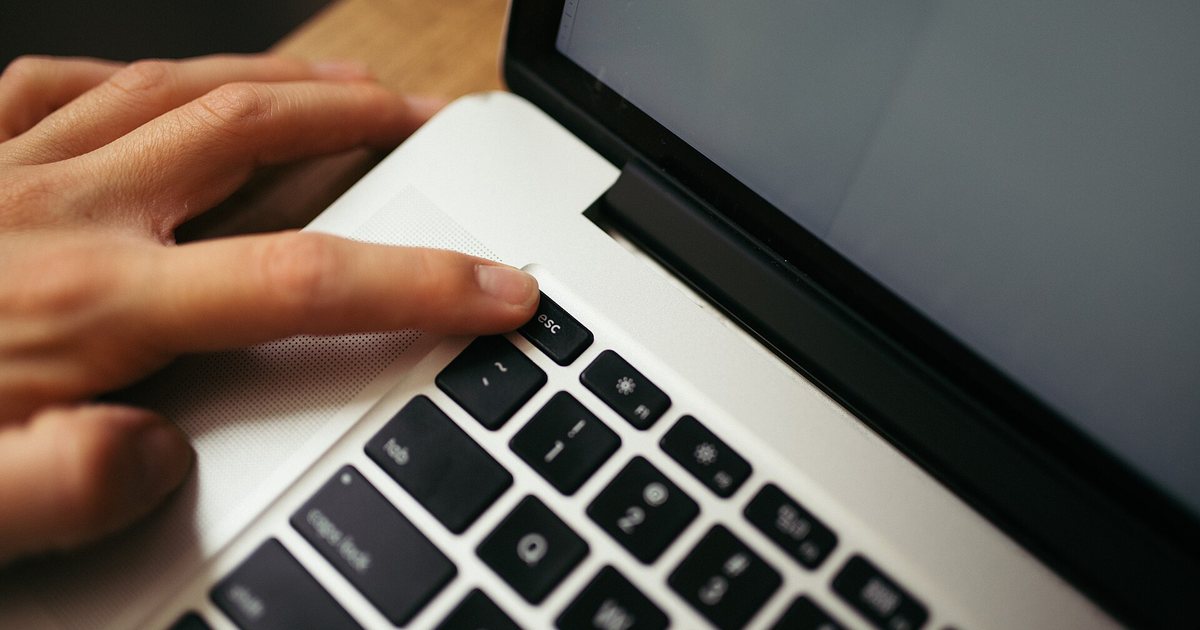 Mano sobre el teclado de una computadora portátil, como las que se usan para consultar un expediente en línea