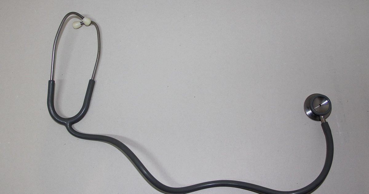 Estetoscopio sobre una mesa blanca, el instrumento de una consulta médica